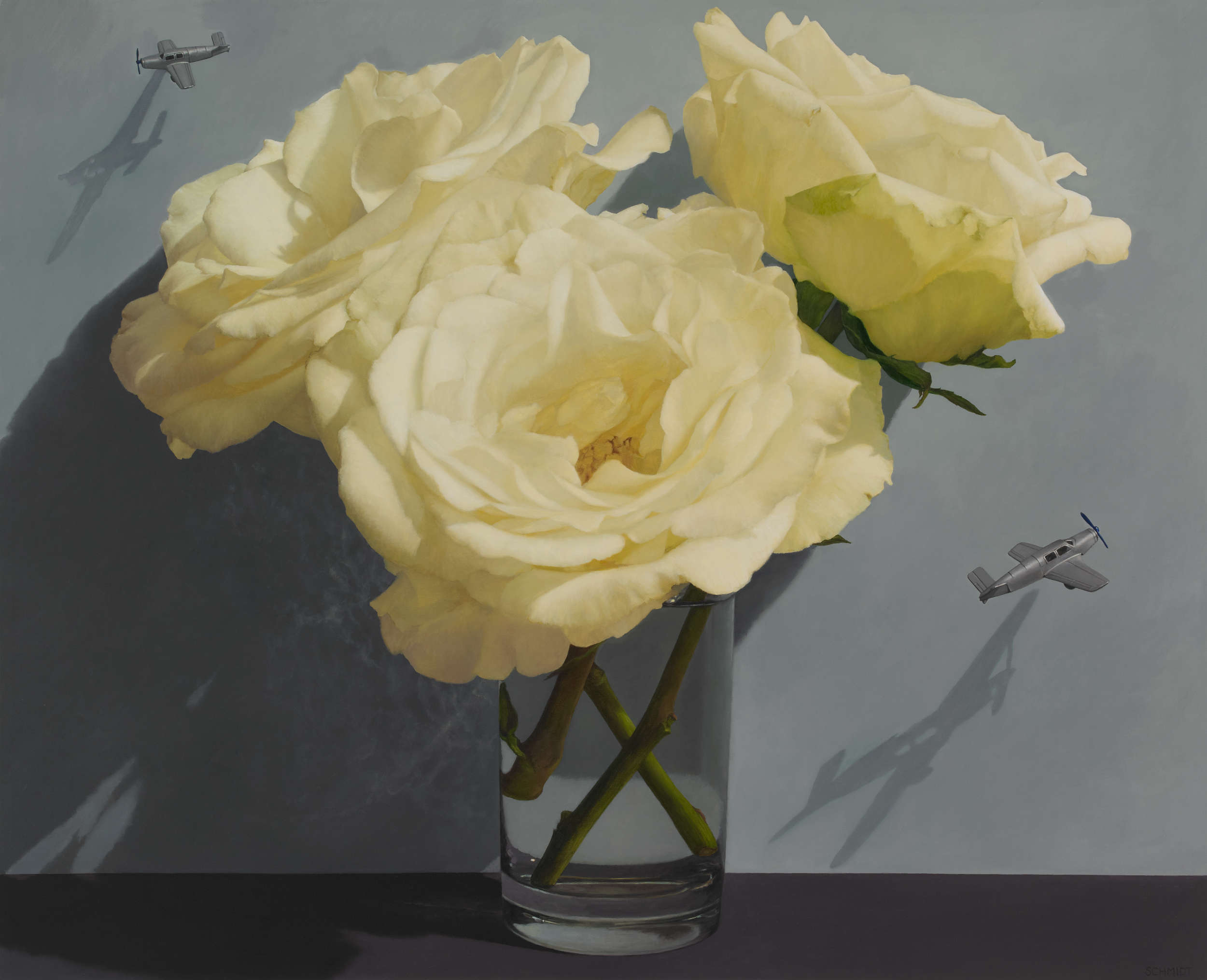 giant white roses in clear vase, dark gray wall, 2 tiny thin silver airplanes flying